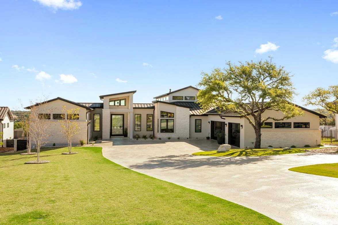 Single-storey limestone home with a live oak and a curved driveway