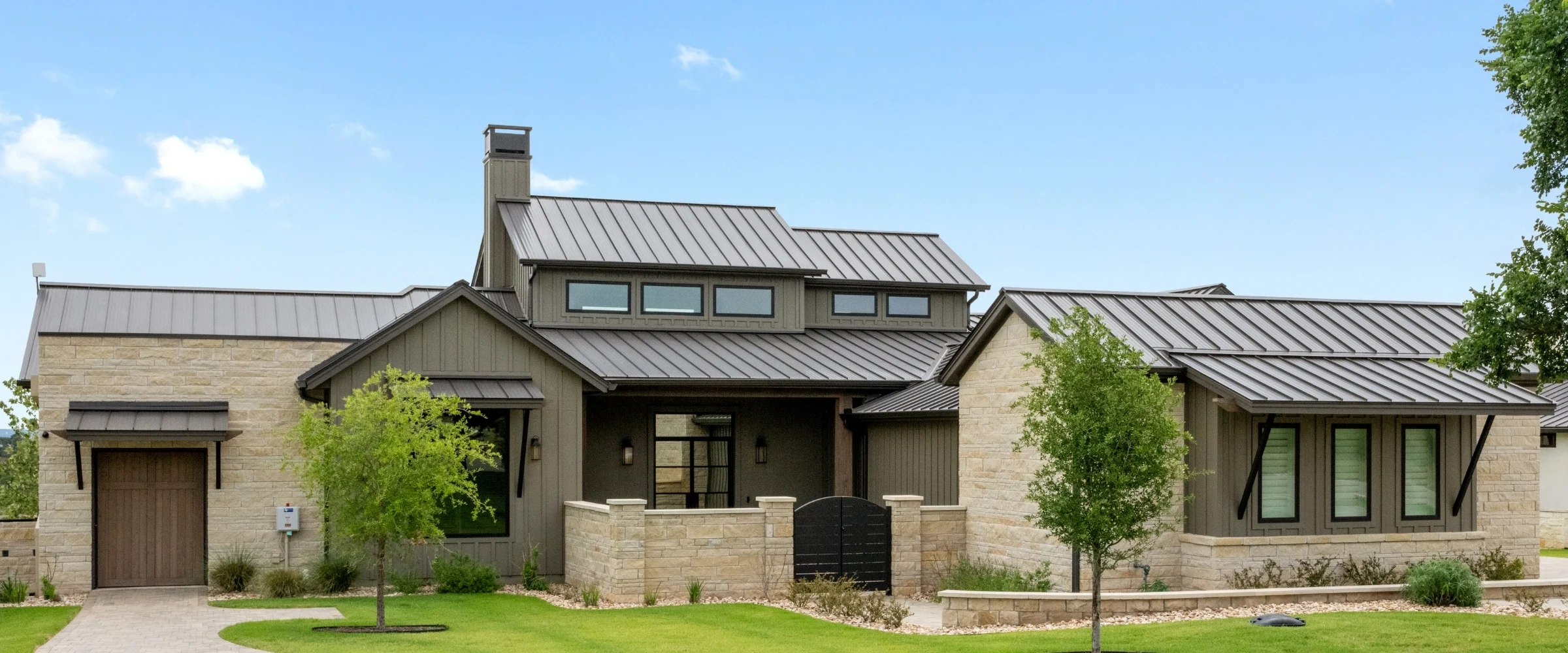 Stone home with board-and-batten siding and a standing-seam metal roof